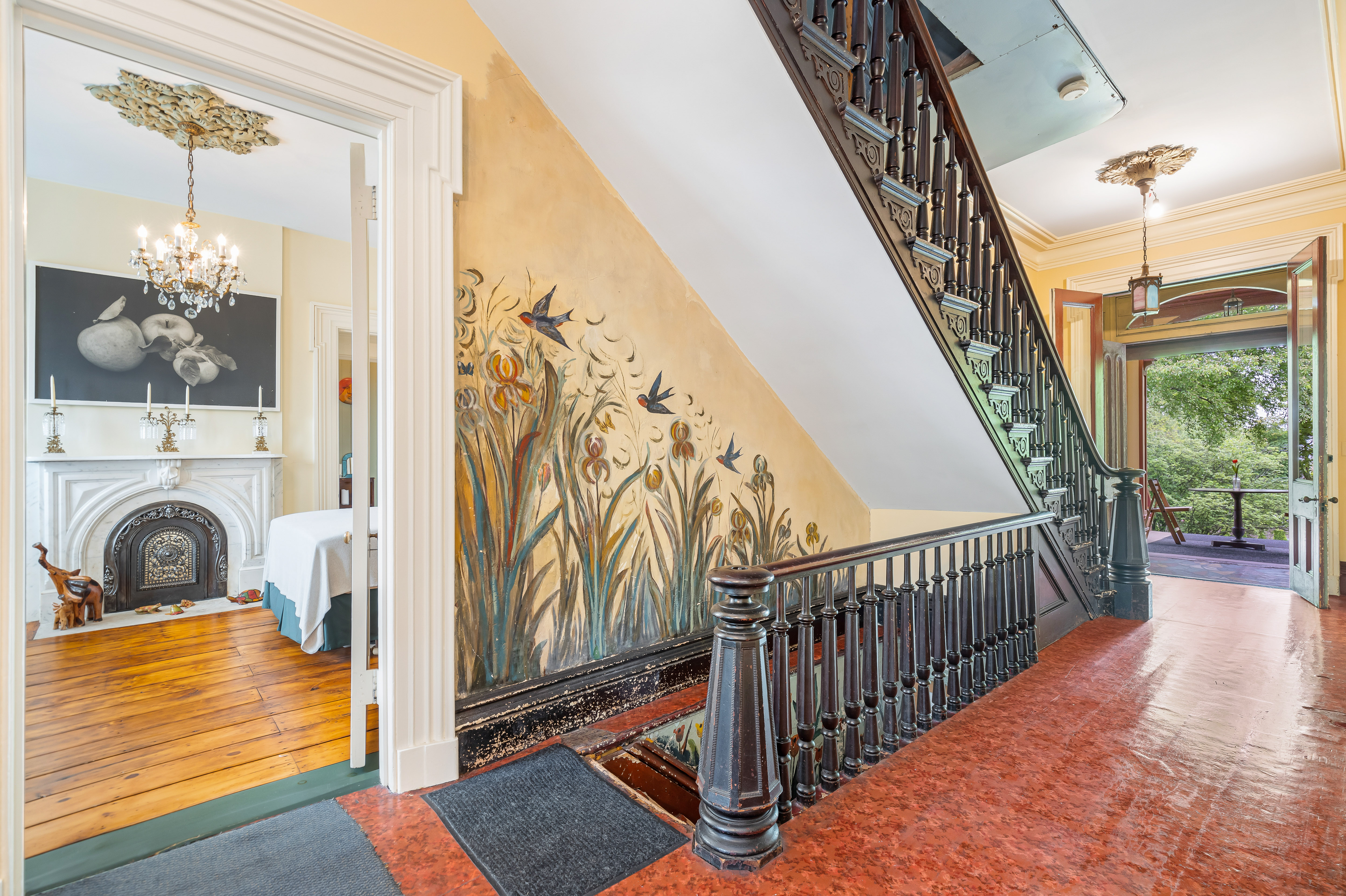 Staircase with mural and parlor view