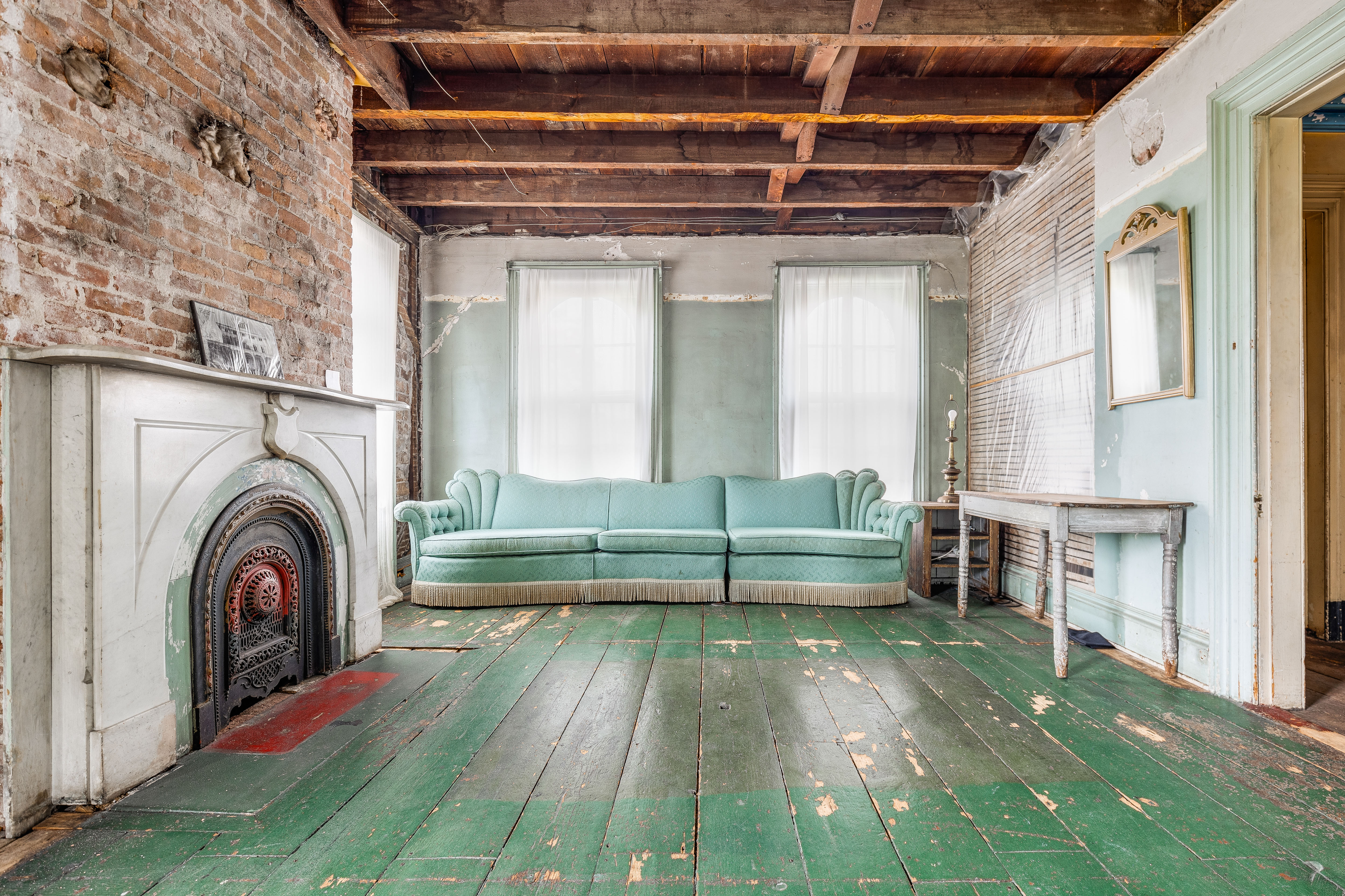 Upper floor with teal sofa and fireplace