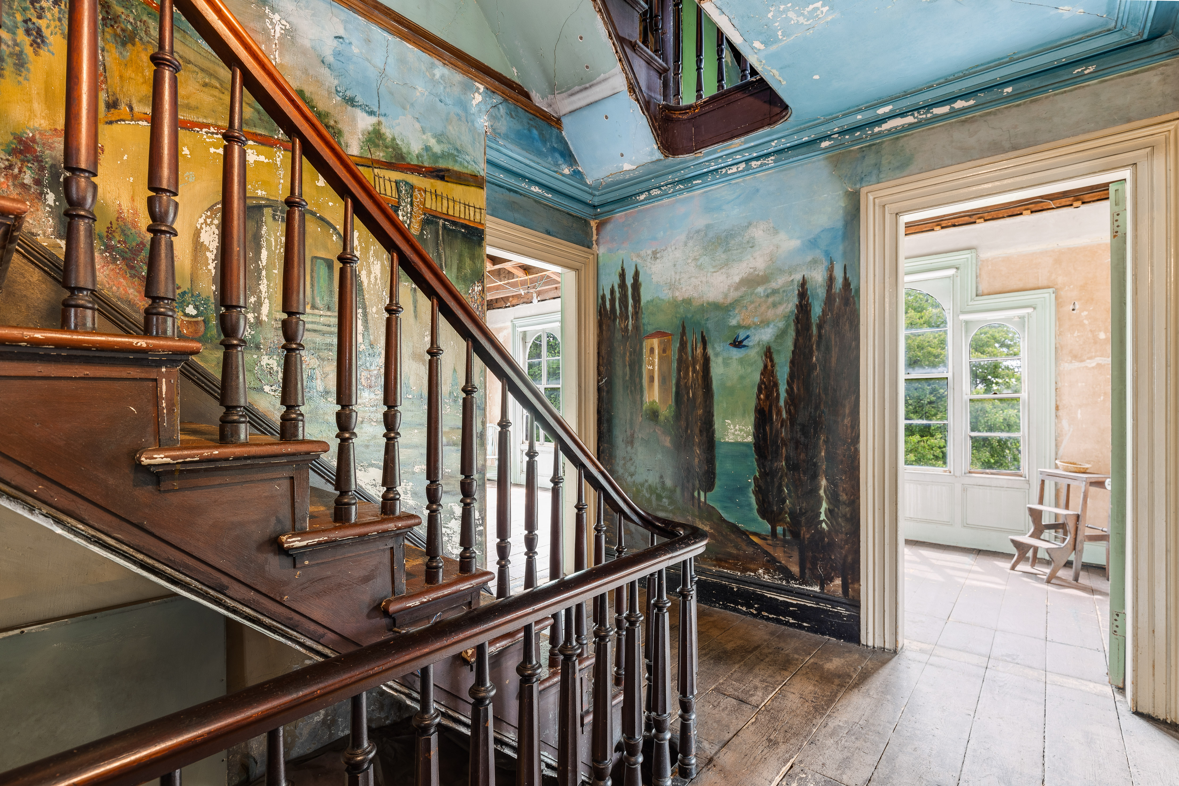 Staircase surrounded by Italian landscape murals