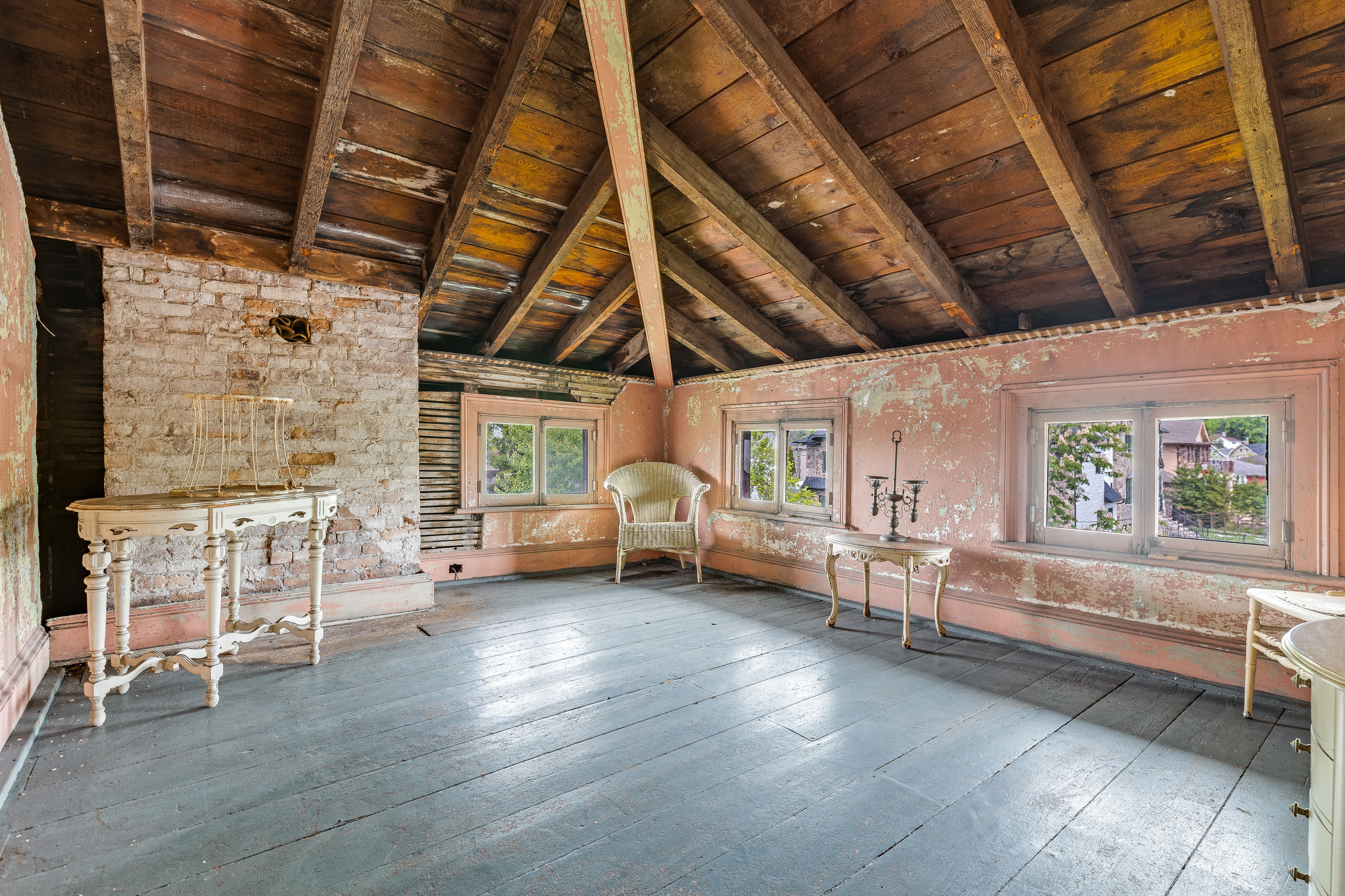 Pink attic room with exposed brick